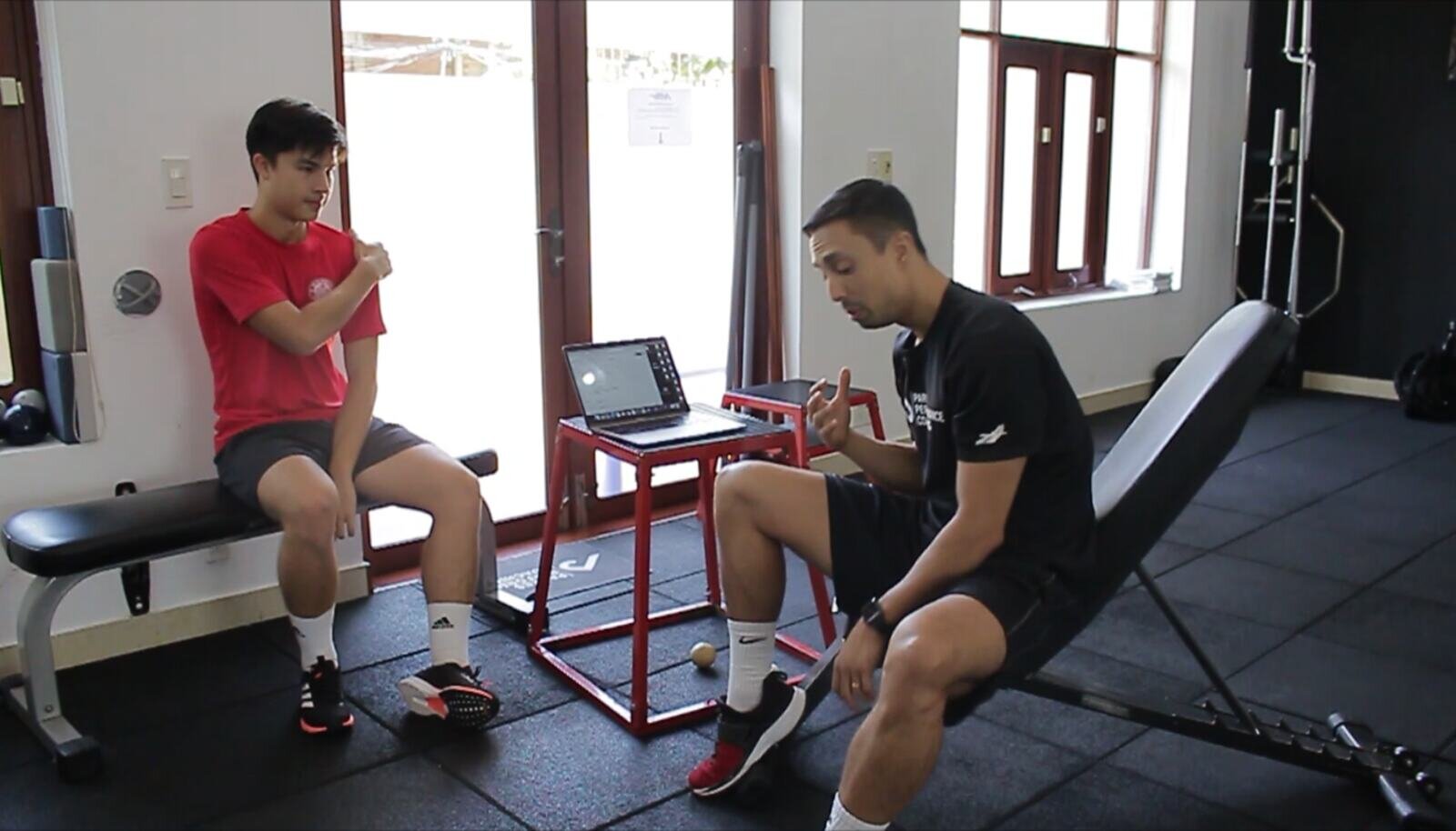 Justin Parkes talking a client through an assessment beside a laptop